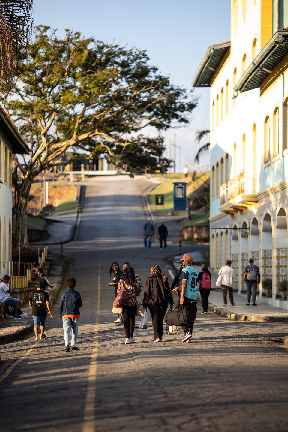 Grupo de visitantes descendo a rua interna do Instituto da Costela, ladeada por casarões coloniais